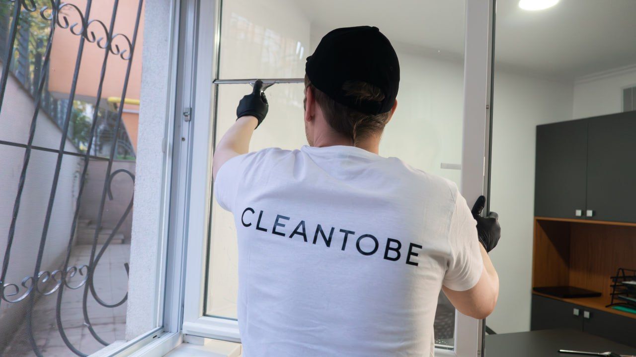 Echipa CLEANTOBE efectuează curățarea geamurilor după reparație într-un spațiu interior